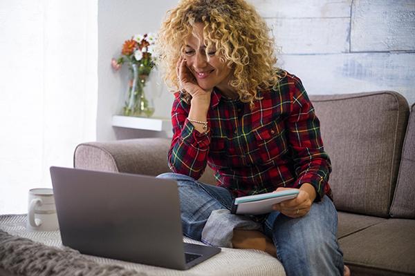 Woman taking notes with laptop